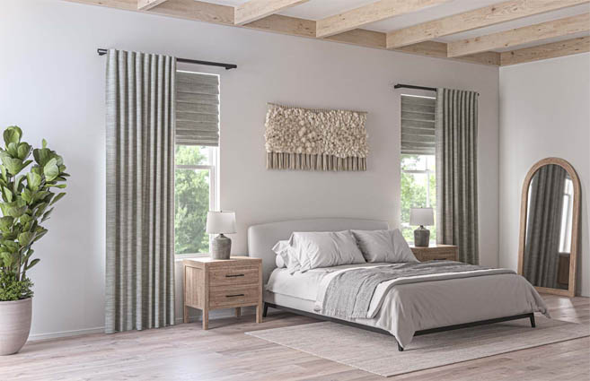 Layered roman shades and drapery in a bedroom