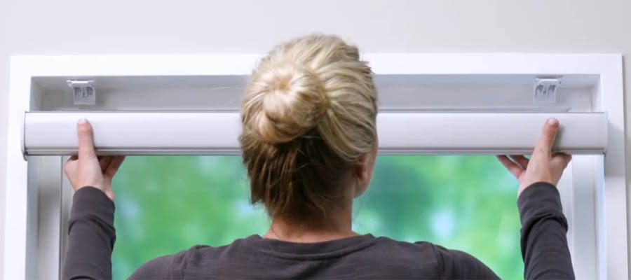 Woman removing motorized blind from brackets